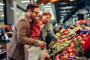 Un père et sa fille achètent des fruits et légumes